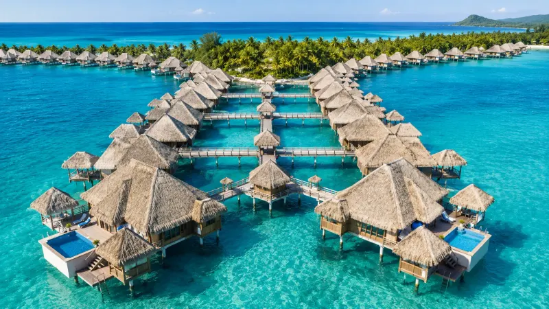 Overwater villas of Bora Bora in French Polynesia. Vacations and tours planned by Piccola Travel, a Miami travel agency.