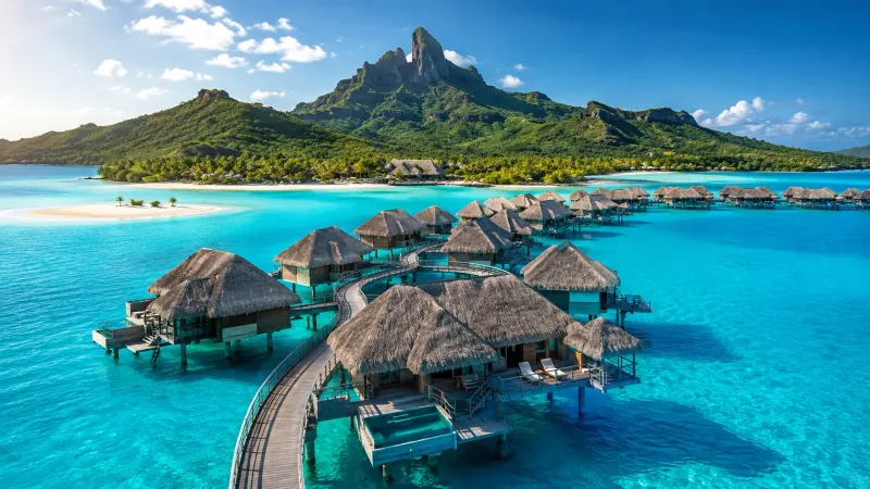 Mount Otemanu rising above the turquoise lagoon and luxury overwater villas of Bora Bora in French Polynesia, planned by Piccola Travel a Florida travel agency.