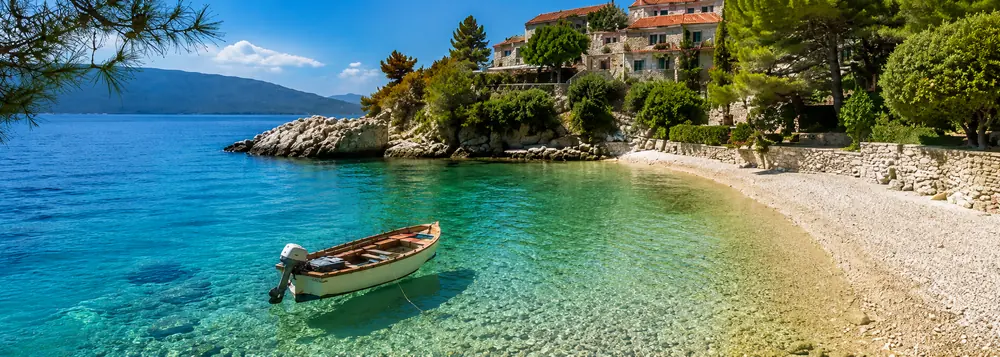A wooden boat in a clear Adriatic cove on a Croatia and Adriatic coast vacation
