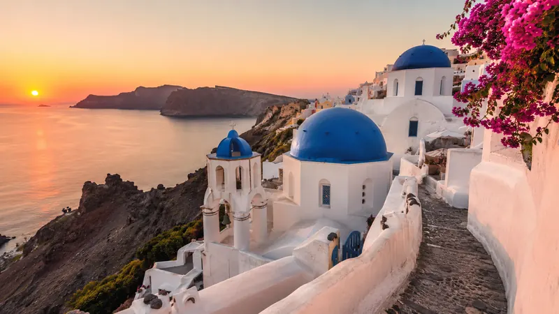 Blue-domed churches at sunset in Santorini, a top Greece honeymoon destination
