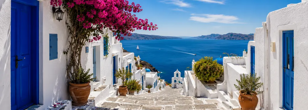 A whitewashed alley with a blue door in Santorini on a Greek islands tour