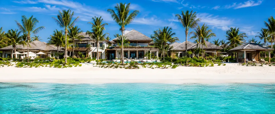 Staffed luxury villa on a white-sand beach with turquoise water
