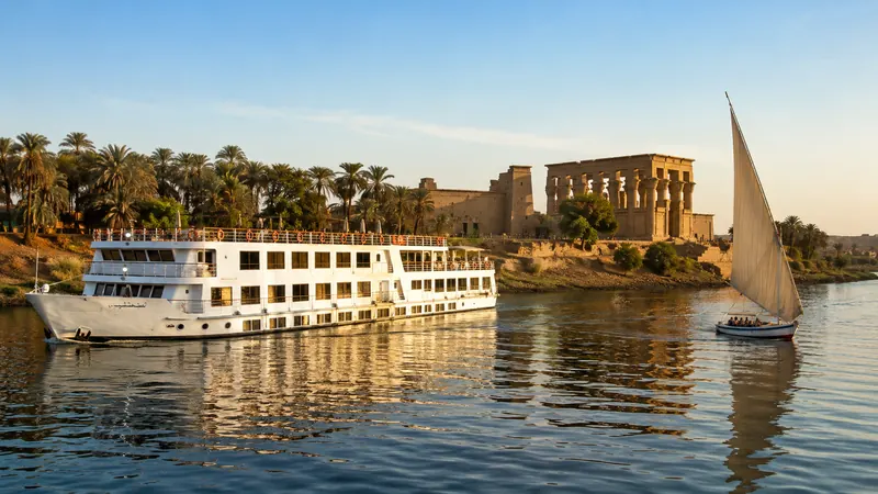 Nile River cruise ship sailing past ancient temple ruins — Nile River cruise Egypt.