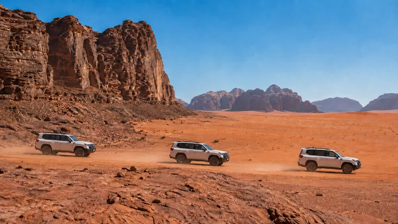 4x4 convoy crossing the red desert canyons of Wadi Rum — Wadi Rum jeep safari.