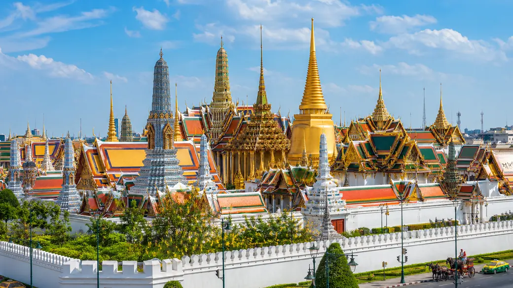 Golden spires of the Grand Palace and Wat Phra Kaew shining under a blue sky in Bangkok on a guided Thailand tour