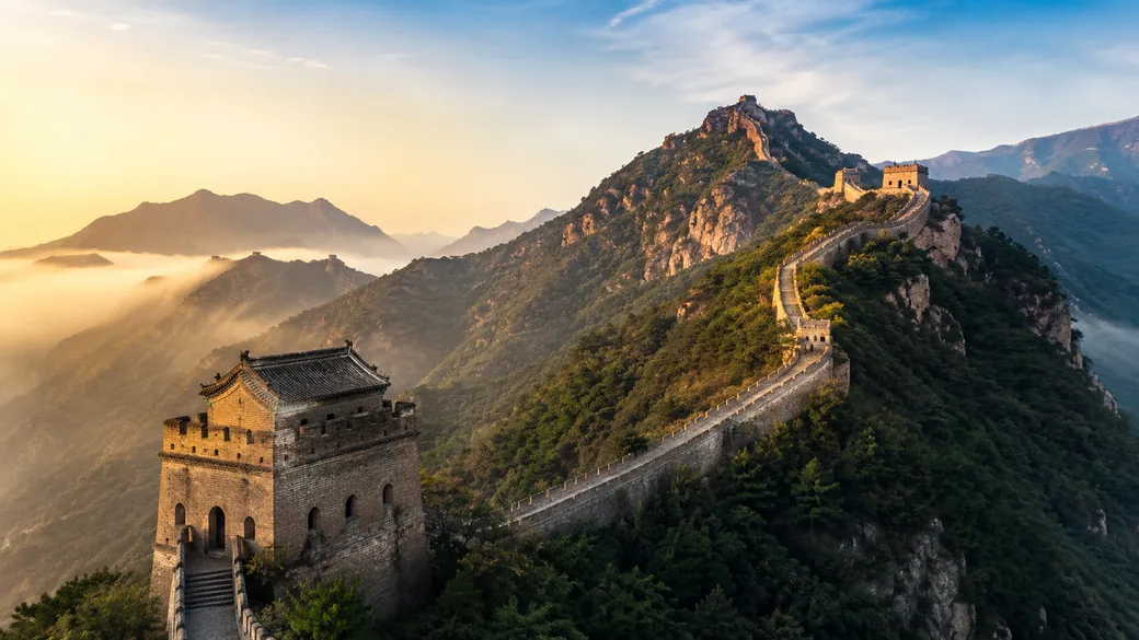 Stone watchtowers of the Great Wall winding over green mountain ridges at Juyongguan on a guided China tour