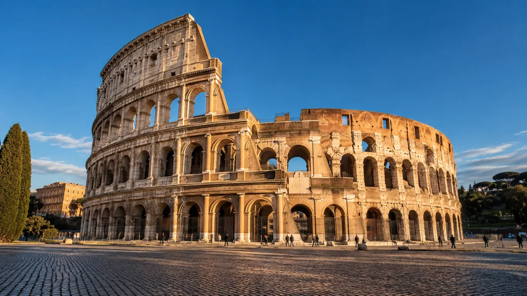 The Colosseum in Rome in warm afternoon light under a blue sky