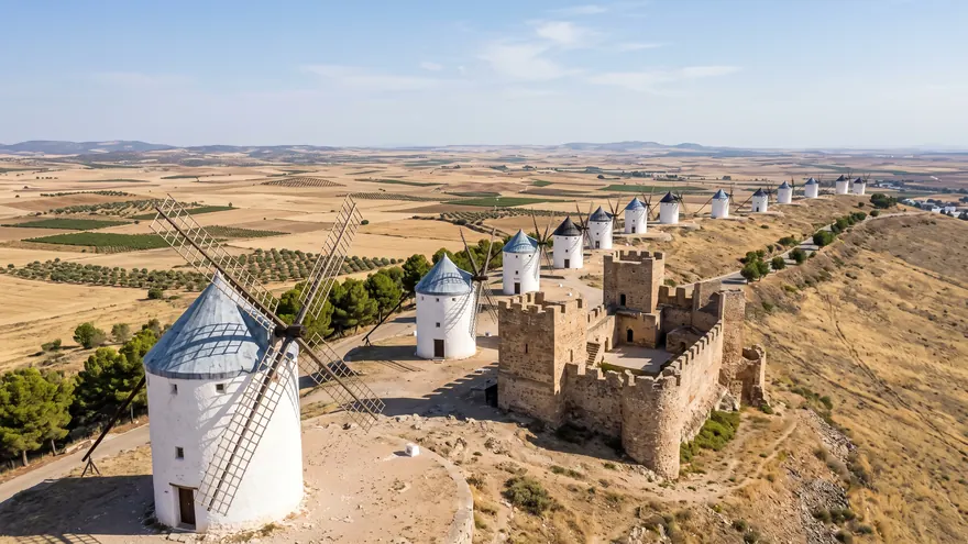 The white windmills of Consuegra lined up beside the castle above the plain of La Mancha