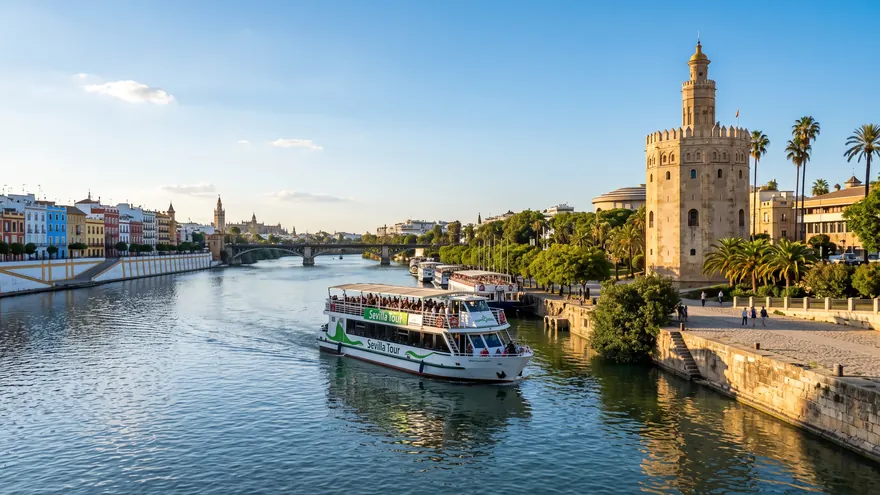 A boat on the Guadalquivir River passing the Torre del Oro in Seville