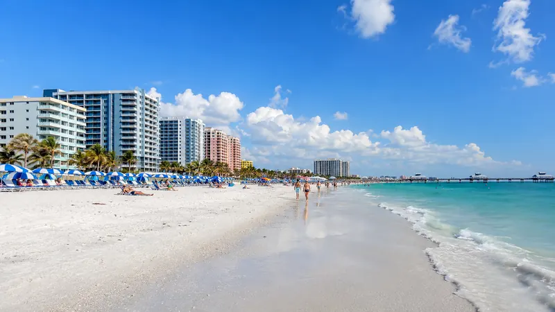 White-sand shoreline with beach umbrellas and gentle surf — coastal beach vacations in the United States.